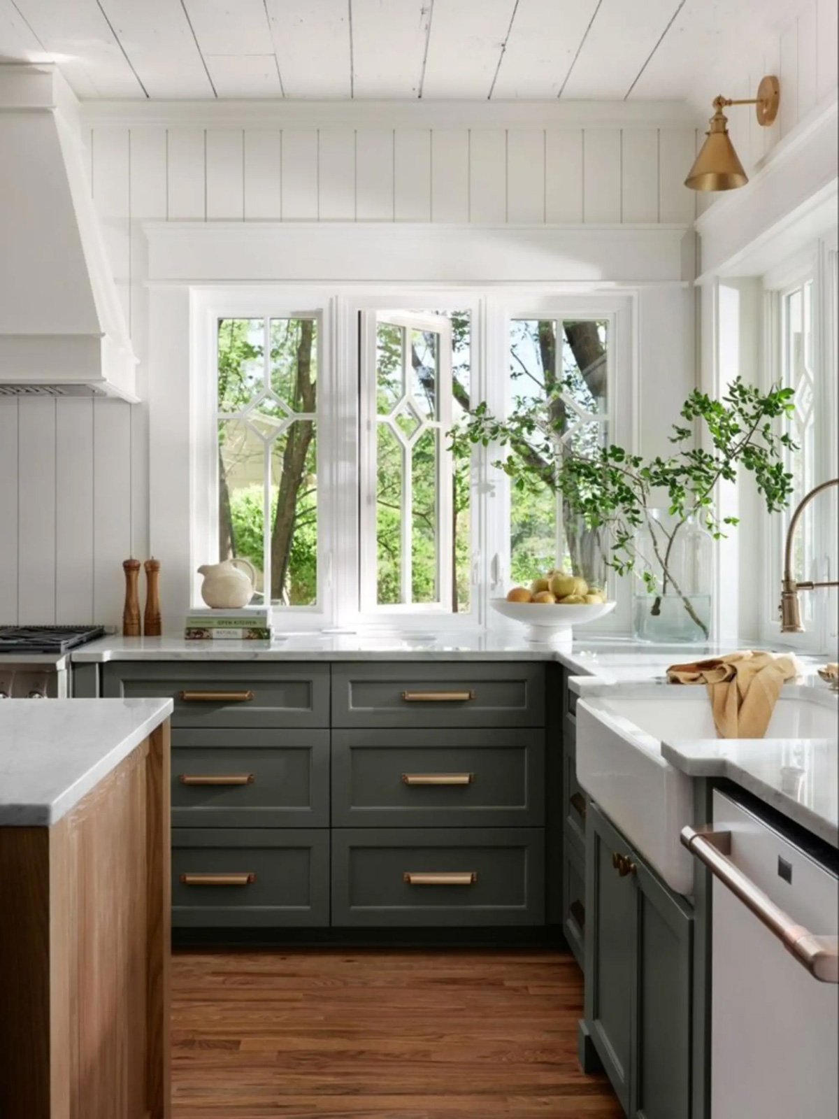 White kitchen walls with hunter green cabinets and bronze color handles.