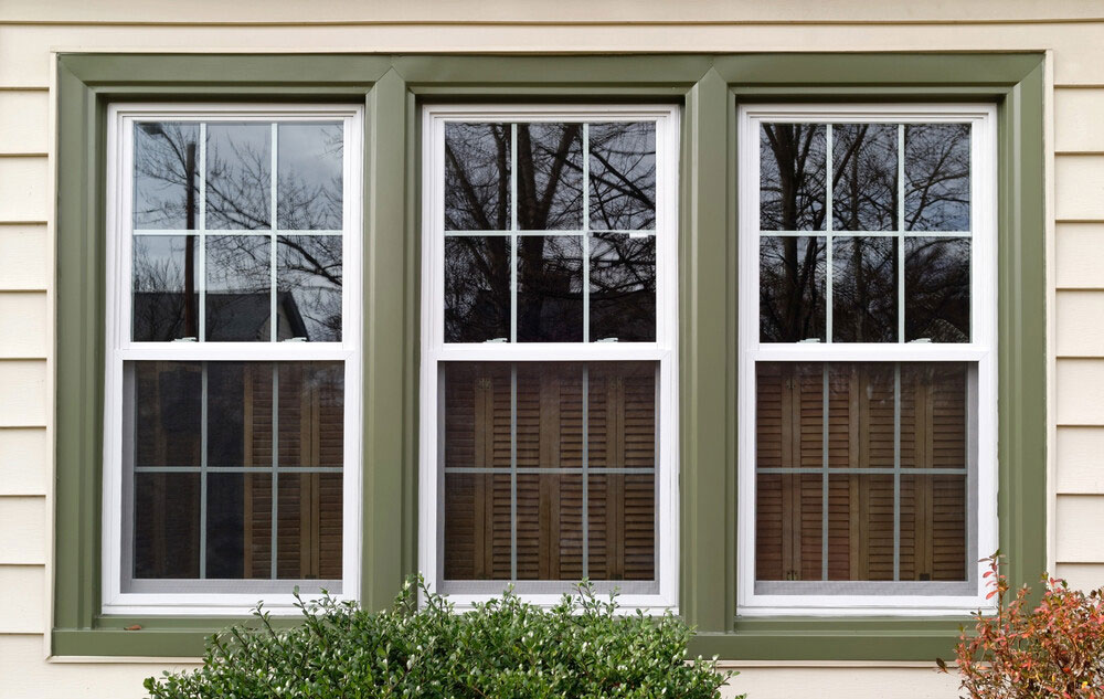 Outdoor view of 3 panel windows with a olive green border.